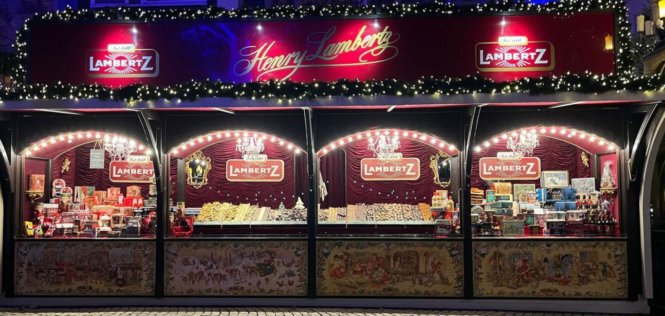 Unser Lambertz-Stand auf dem Weihnachtsmarkt in Köln zeigt das Sortiment von Lambertz-Weihnachtsgebäck und Lambertz-Geschenkdosen.